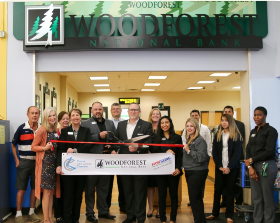 Pictured  center (left to right) are Daniel Soptick, Branch Manager, Assistant VP  (holding scissors); Mike White, Divisional Manager, Sr. VP – Retail;  and Lynda Eddy Assistant Branch Manager; along with bank associates and  members of the Conroe/Lake Conroe Chamber of Commerce.