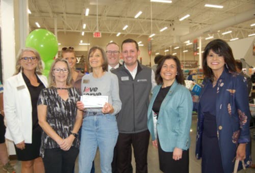 Society of Samaritans (SOS) received a $10,000 donation from Woodforest Charitable Foundation. Pictured are Beverly Points, SOS Secretary and Financial Counselor (holding check), Becky Benham, SOS Executive Director (3rd from left), and Tammy Teale, SOS Assistant Executive Director (2nd from left), along with Woodforest’s Brett Simms, Assistant VP and Branch Manager (center), and Julie Mayrant, President, and Chief Retail Officer (2nd from right), along with other bank team members.